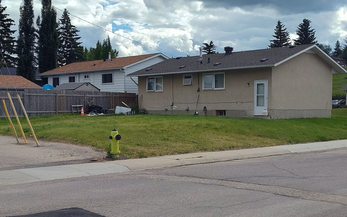 A 1960s stucco bungalow with a side-wall furnace vent in the Bonavista Downs community of south-east Calgary